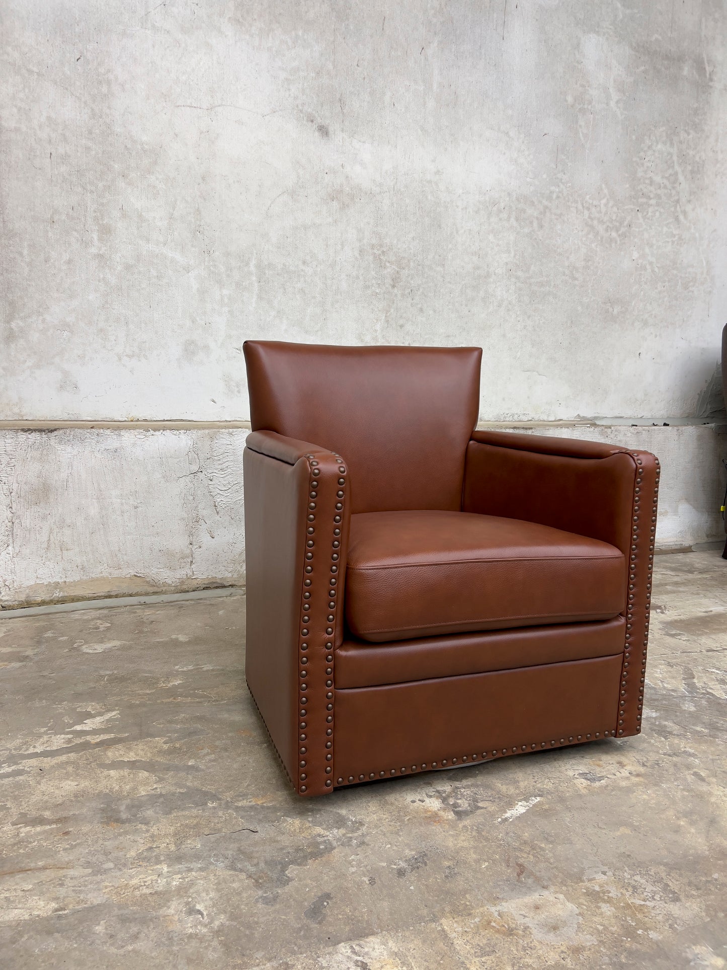 contemporary genuine leather swivel chair with nailhead trim on the arms