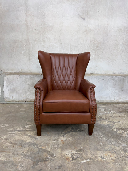 Genuine leather armchair featuring nailhead trims and solid wood legs.