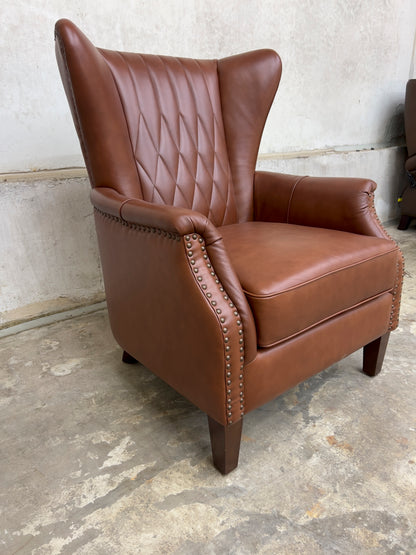 Genuine leather armchair featuring nailhead trims and solid wood legs.