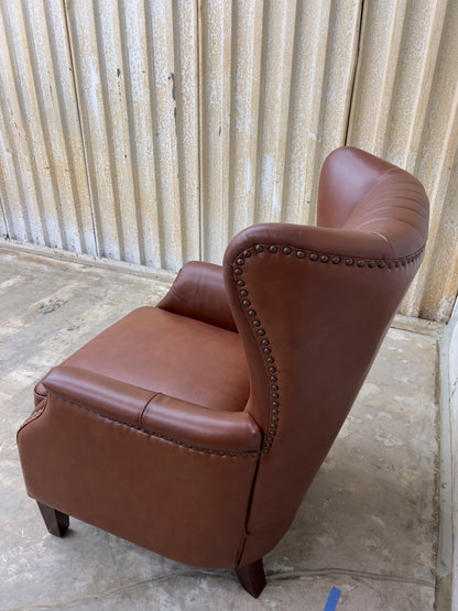 Genuine leather armchair featuring nailhead trims and solid wood legs.