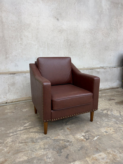 Vegan Leather Brown Armchair featuring solid wood legs and nailhead trim.