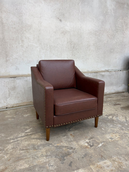 Vegan Leather Brown Armchair featuring solid wood legs and nailhead trim.