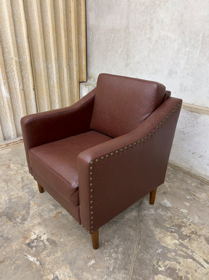 Vegan Leather Brown Armchair featuring solid wood legs and nailhead trim.