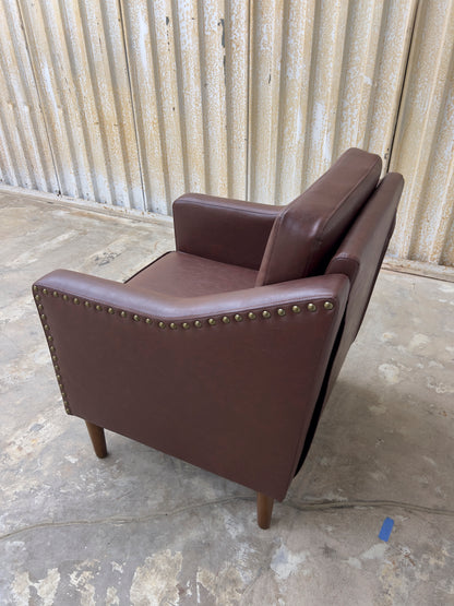 Vegan Leather Brown Armchair featuring solid wood legs and nailhead trim.
