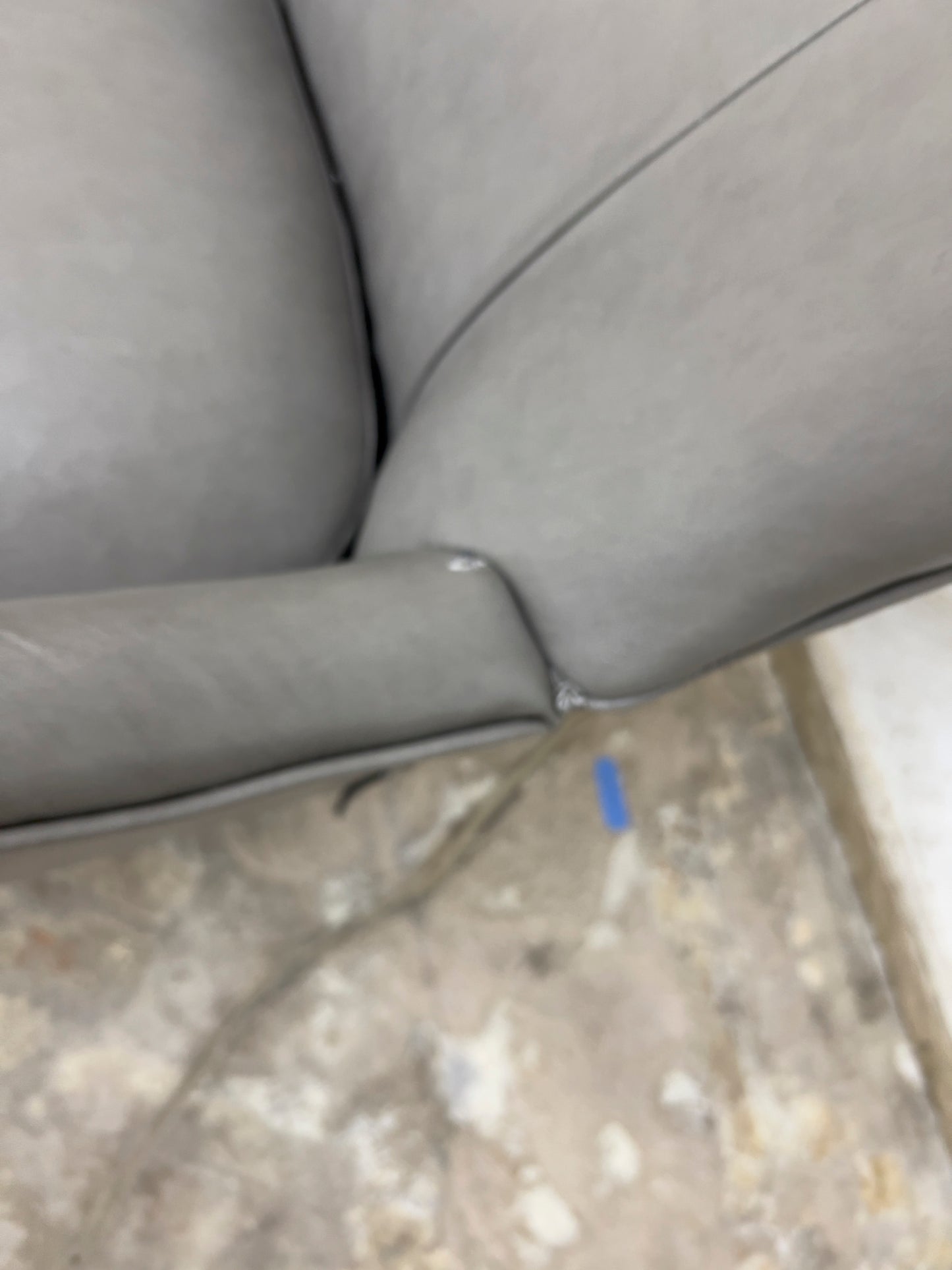 Grey Armchair, which features vegan leather upholstery, nailhead trim, and metal legs.