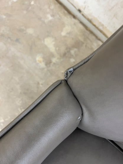 Grey Armchair, which features vegan leather upholstery, nailhead trim, and metal legs.