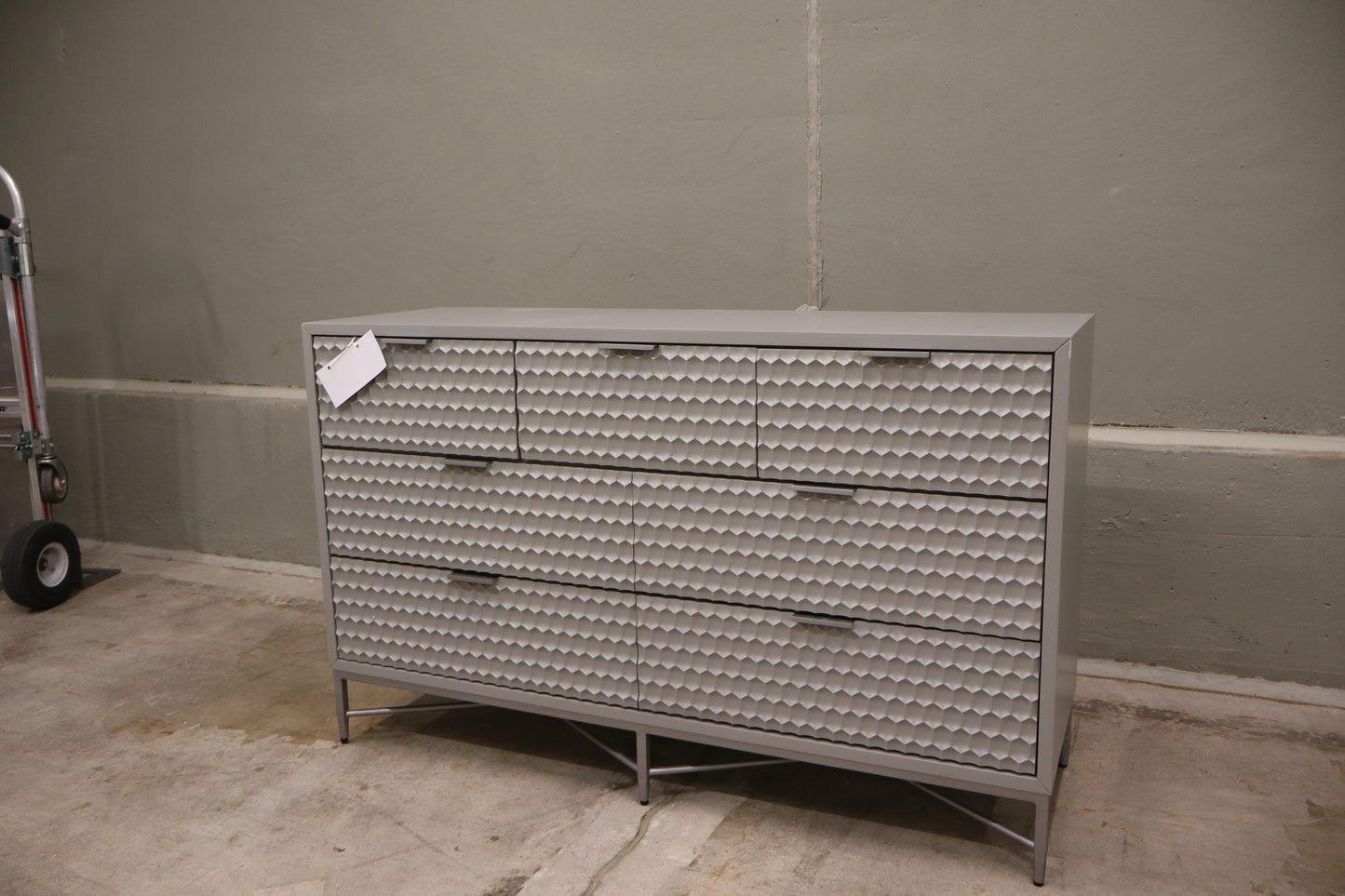 Milo 7 Drawer Dresser, featuring a taupe finish with textured drawer faces and pewter hardware. 