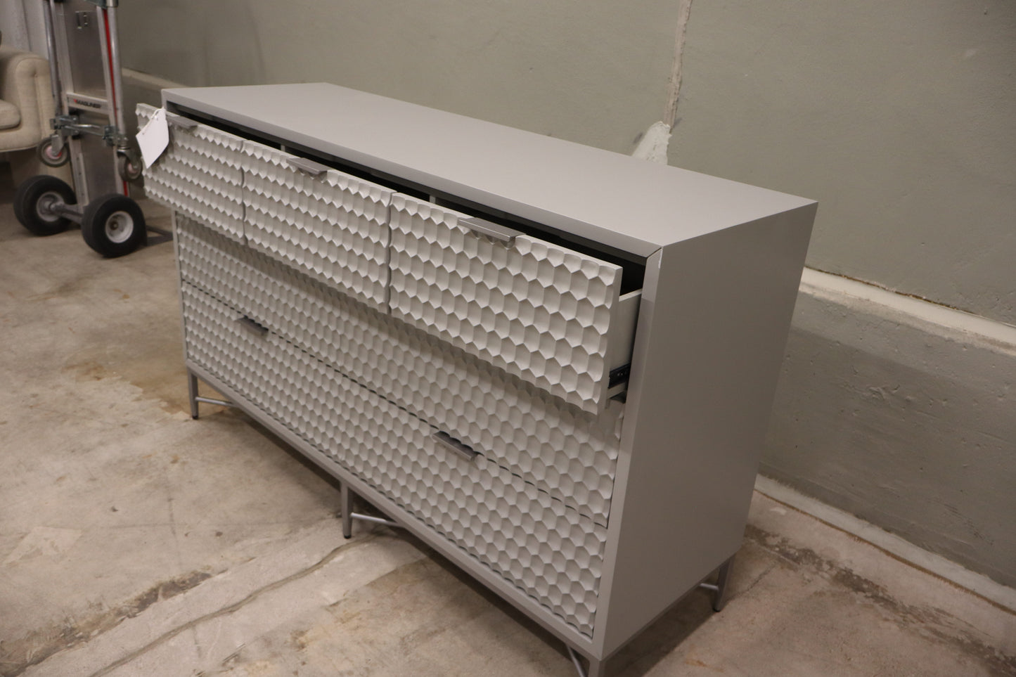 Milo 7 Drawer Dresser, featuring a taupe finish with textured drawer faces and pewter hardware. 