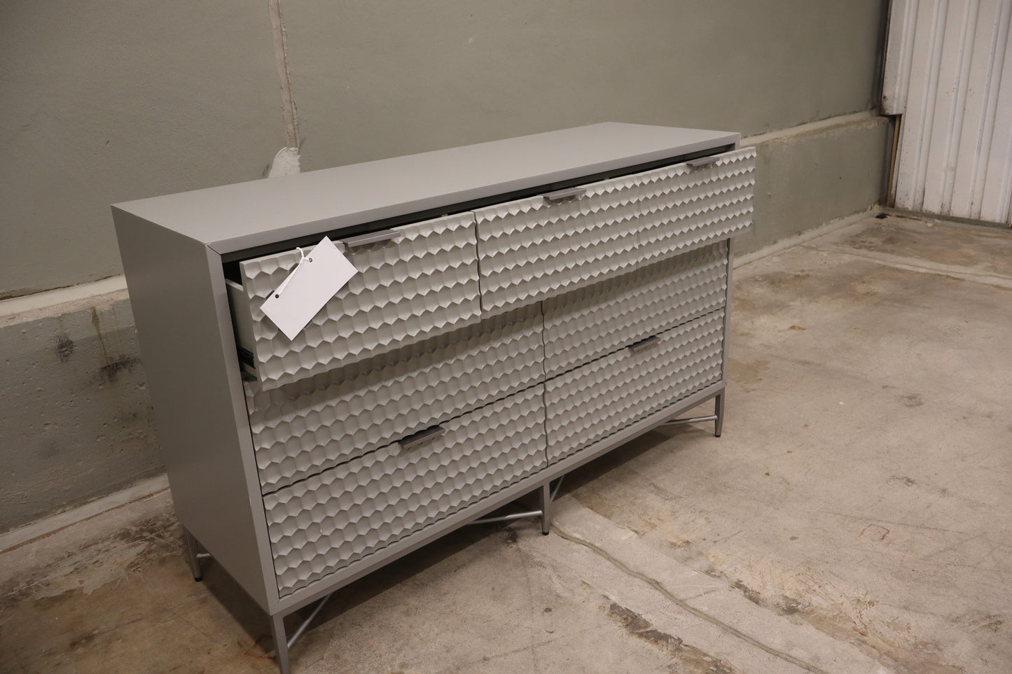 Milo 7 Drawer Dresser, featuring a taupe finish with textured drawer faces and pewter hardware. 